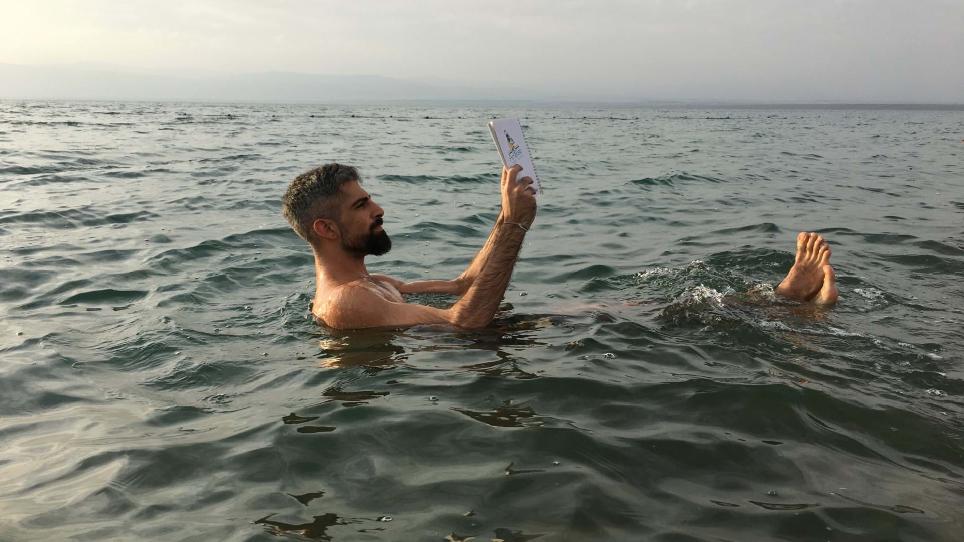 Vodič Petar Sretenović čita knjigu u Mrtvom Moru u Jordan