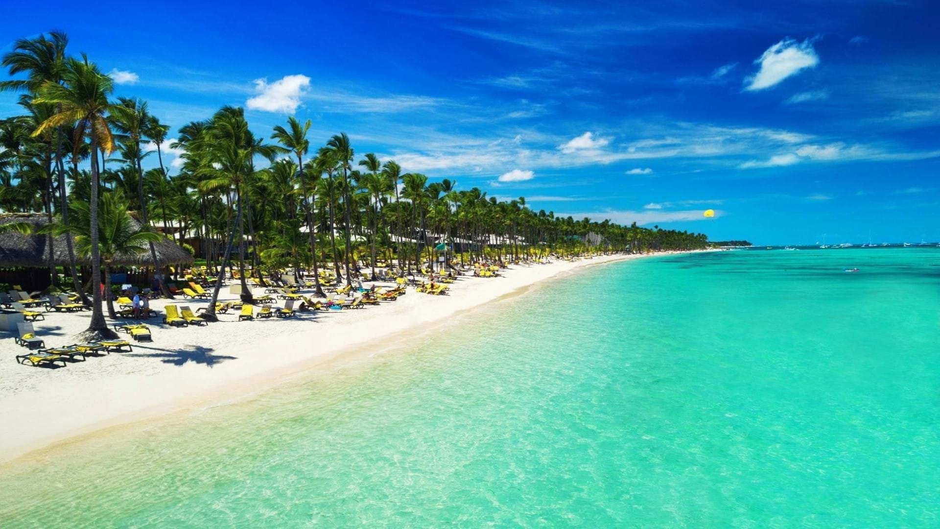 Plaža jednog od mnogobrojnih rizort hotela u Punta Kani u Dominikanskoj Republici. Beli pesak, tirkizno more i predivna obala sa palmama i barom za goste hotela.