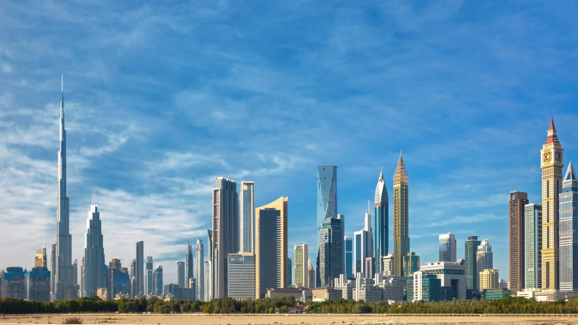 Dubai, pogled na solitere i Burj Kalifu sa obale mora. Mnoštvo nebodera i vedro nebo
