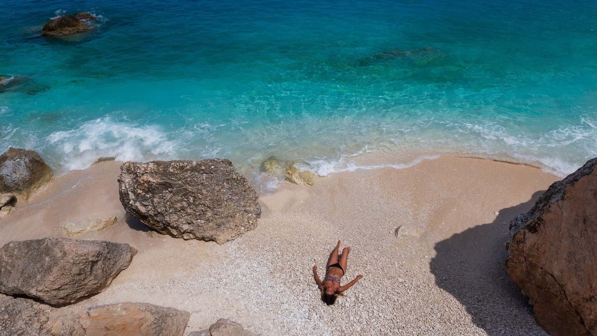 Devojka na prelepoj plaži u uvali stena na ostrvu Kefalonija u Grčkoj.
