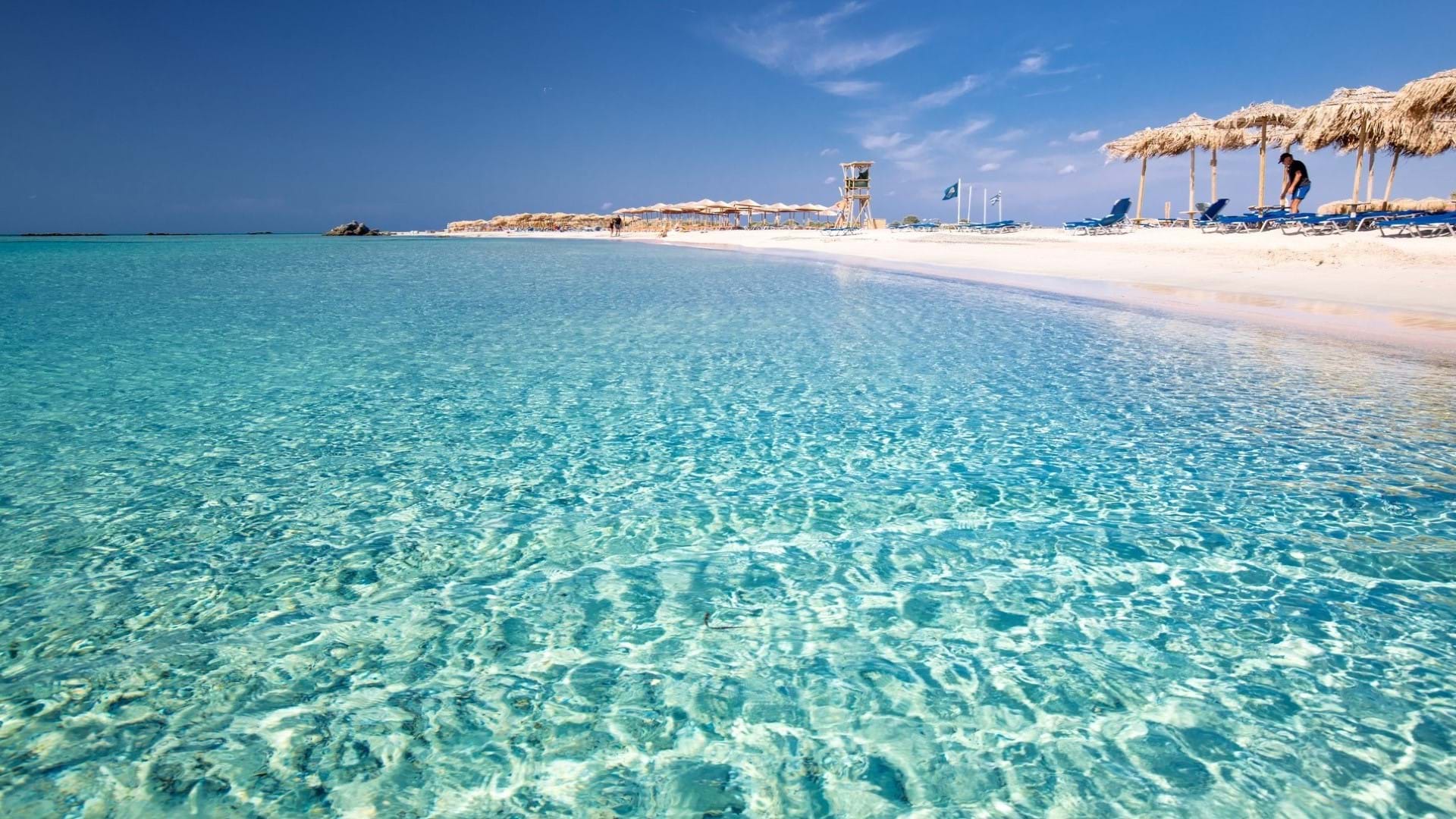 Plaža na Kritu sa tirkiznom boojom mora i belim peskom.