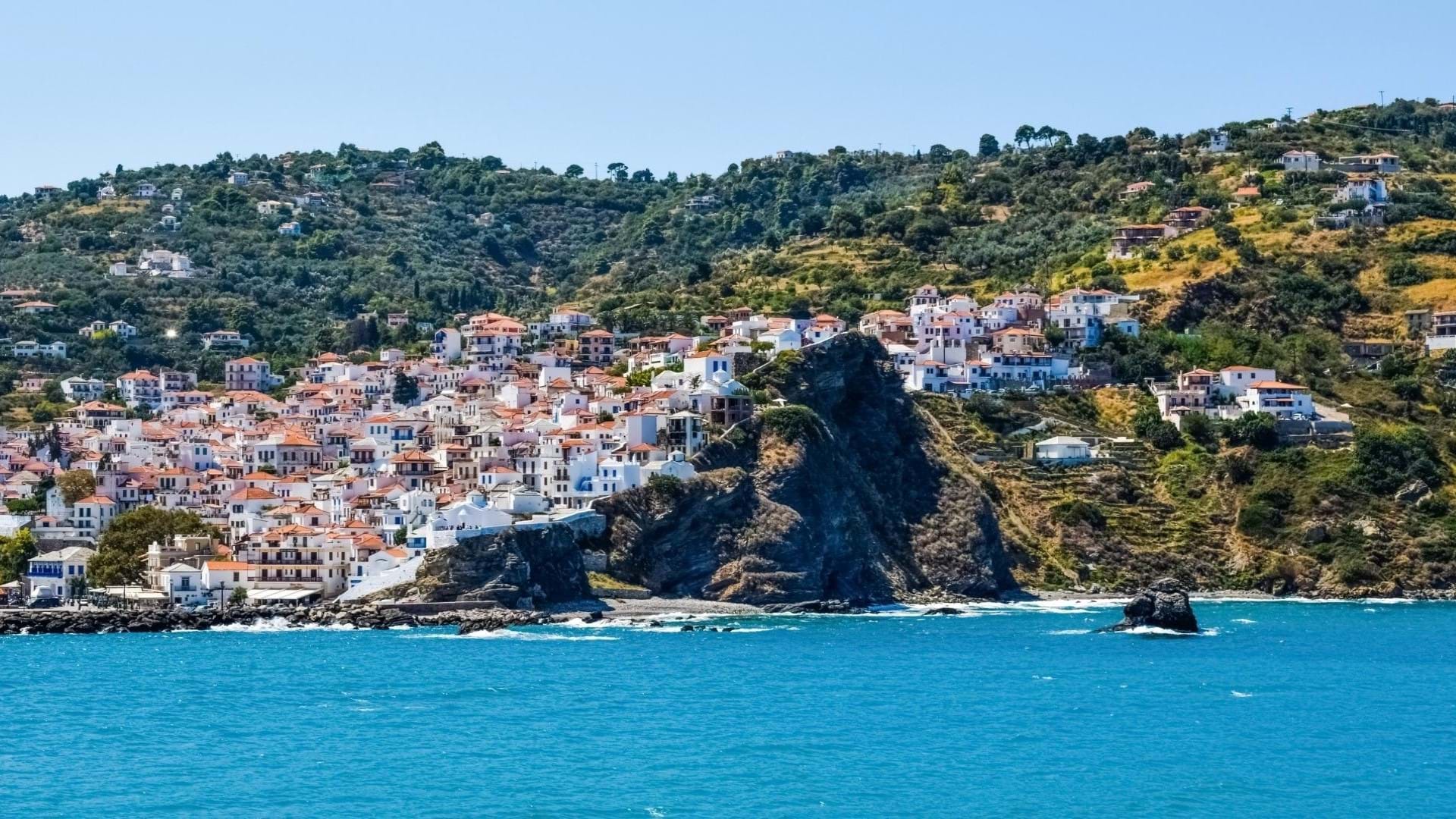 Ostrvo Skopelos u Grčkoj, slikano sa broda i pučine. Prelepo naselje na strmoj obali ostrva.