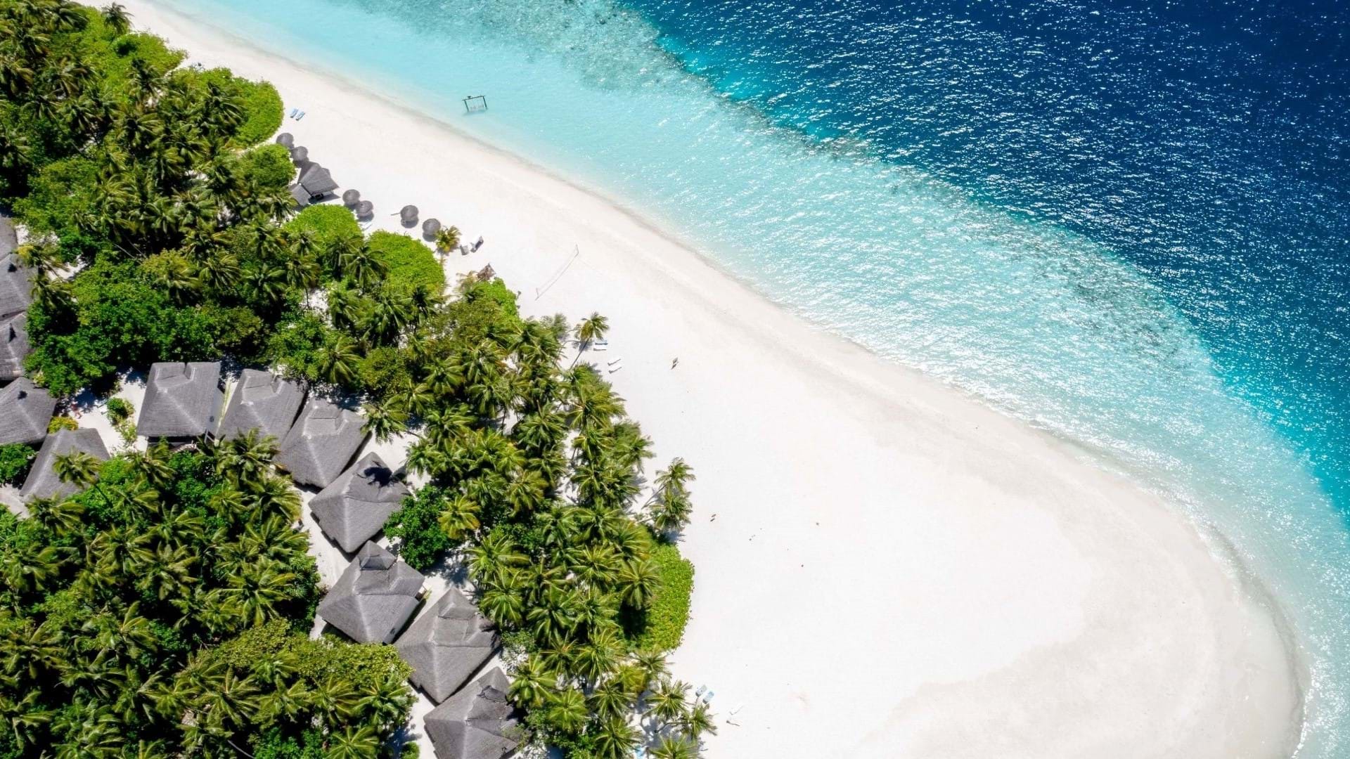 Predivna plaža sa belim peskom na Mauricijusu, hotelski kompleks na obali i tirkizno more.
