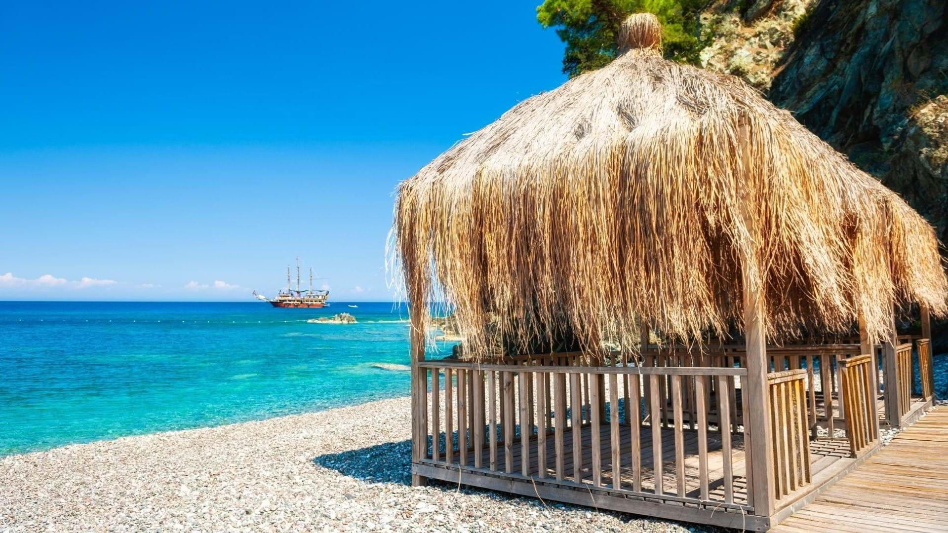 Kemer Letovanje, hotelska plaža sa tirkiznom bojom mora i plavom zastavom.