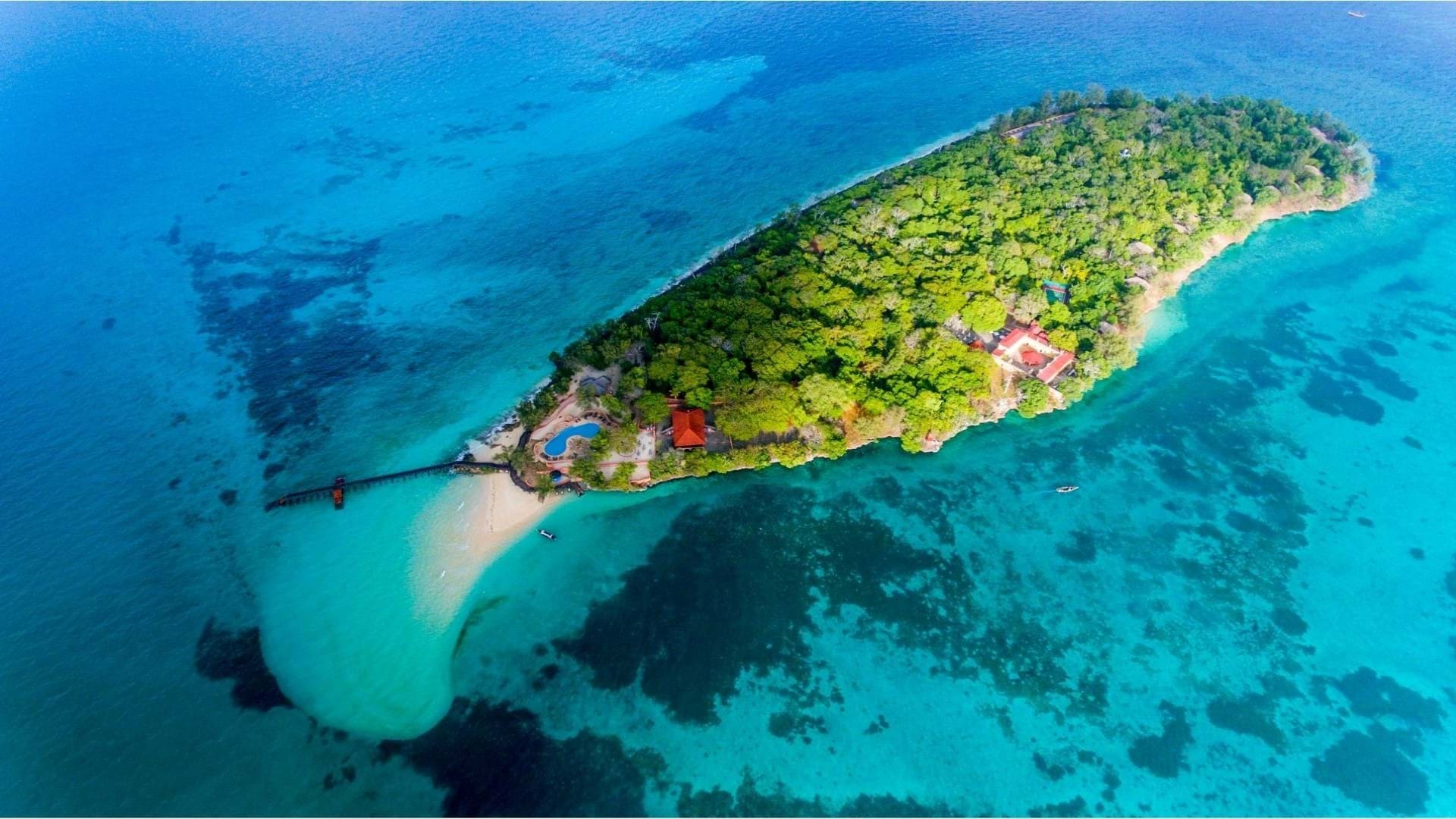 Prison Island na Zanzibaru u Tanzaniji, izletište slikano iz aviona. Koralni grebeni u okolini i tirkizna boja mora. Ostrvo sa puno zelenila